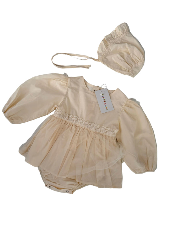 A baby outfit set in cream/off-white fabric, including a long-sleeve ruffled romper with lace trim and a matching bonnet, laid flat on a light surface.