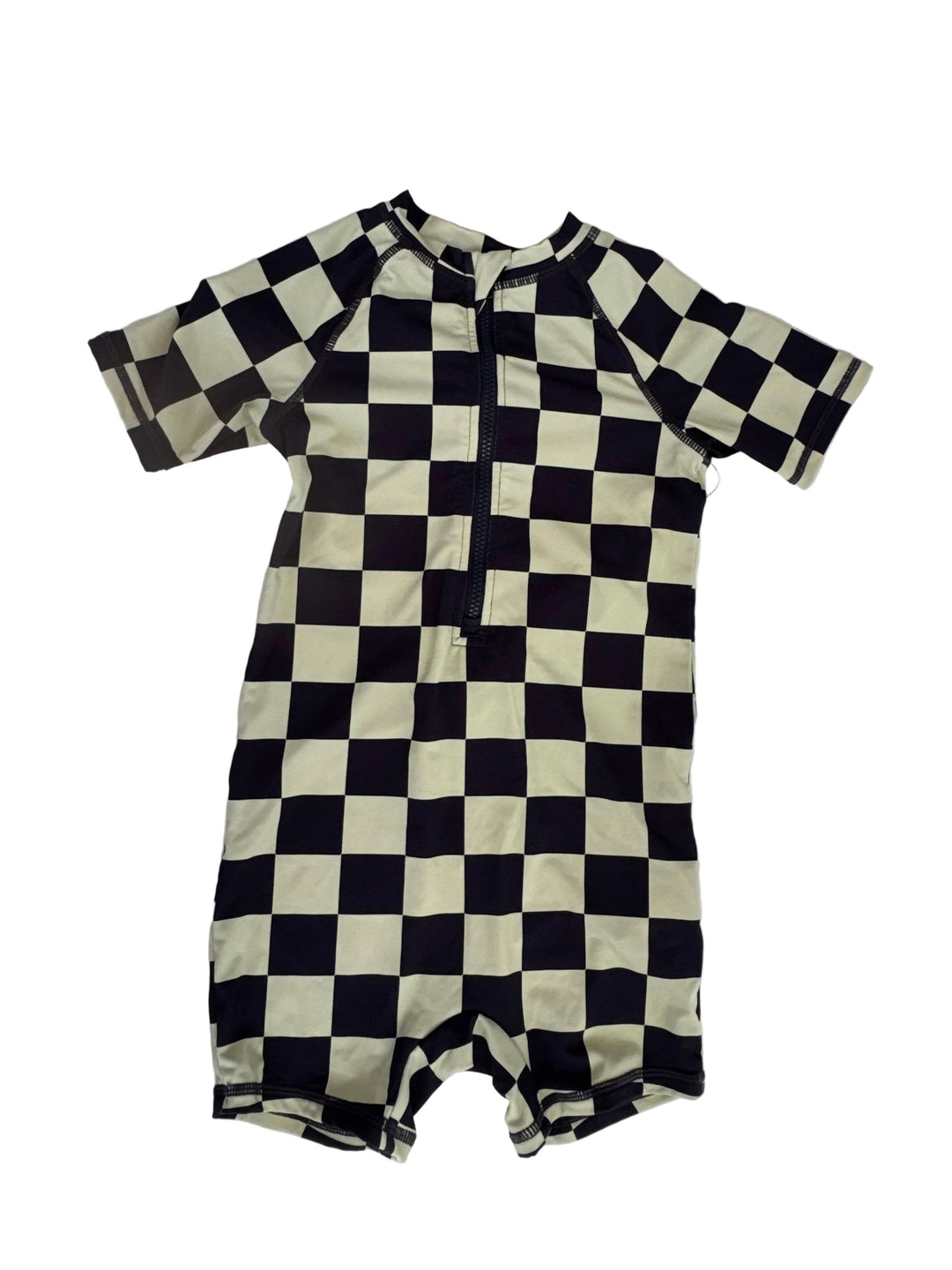 A long-sleeve baby romper with a black and cream checkerboard pattern, laid flat on a white background.