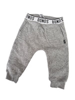 Load image into Gallery viewer, A pair of heather gray sweatpants with a white elastic waistband featuring the brand name 'BONDS' in black text, laid flat on a white background.
