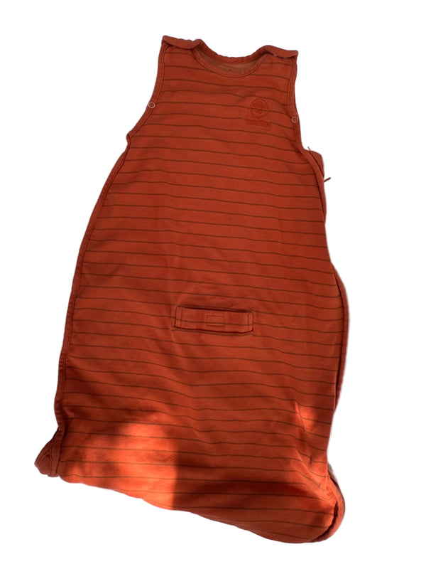 An orange-brown sleeveless top with thin vertical black pinstripes, laid flat on a white surface with dappled sunlight and shadows.