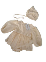 Load image into Gallery viewer, A baby outfit set in cream/off-white fabric, including a long-sleeve ruffled romper with lace trim and a matching bonnet, laid flat on a light surface.
