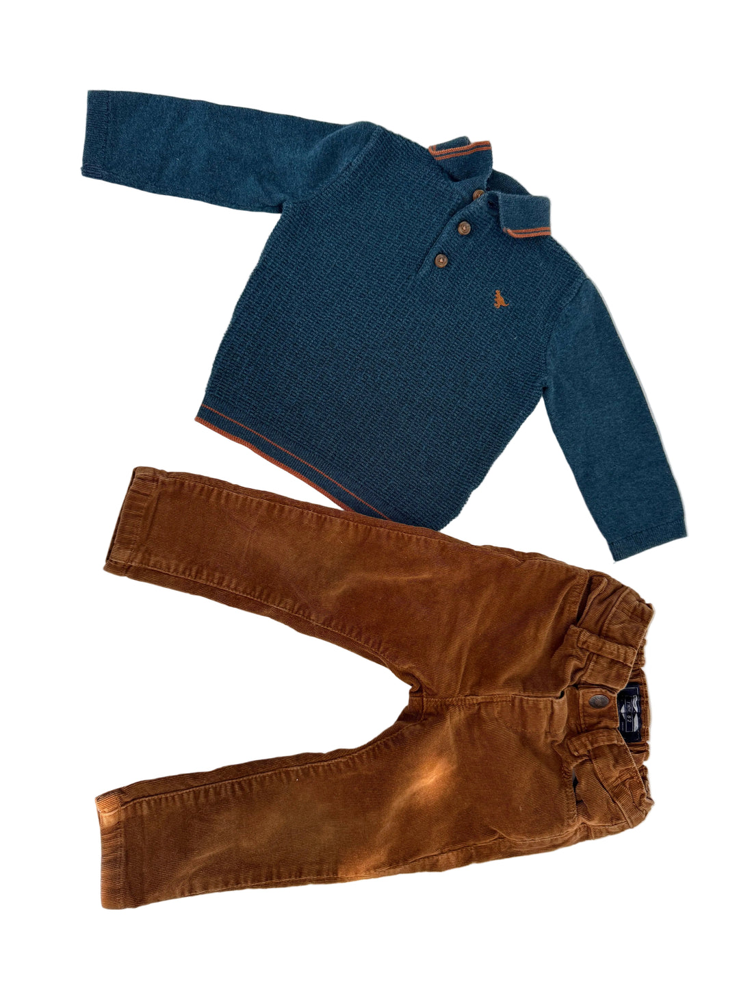 A toddler clothing set consisting of a navy blue knit polo shirt with orange striped collar and cuffs, and brown corduroy pants, laid flat on a white background.
