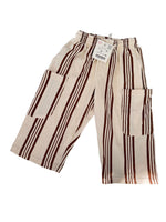 Load image into Gallery viewer, A pair of wide-leg linen pants in cream with dark brown stripes, laid flat on a light gray surface with soft leaf shadows.
