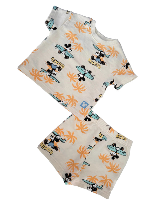A two-piece baby clothing set featuring a short-sleeve top and matching shorts with an all-over Mickey Mouse and palm tree print on an off-white background.